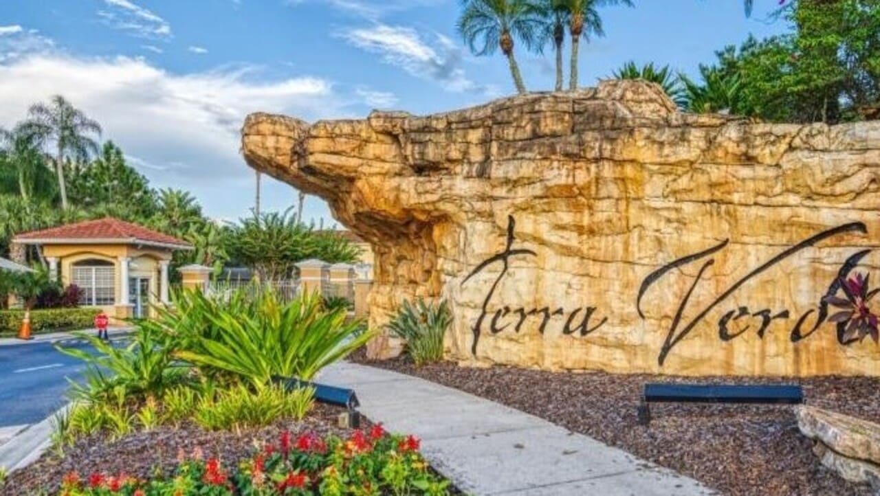 Stone entrance monument lettered Terra Verde, beside the guardhouse and palms